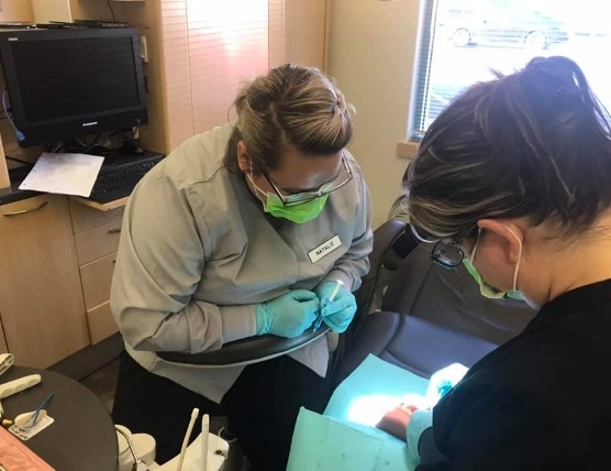 Dental assisting student working in dental office