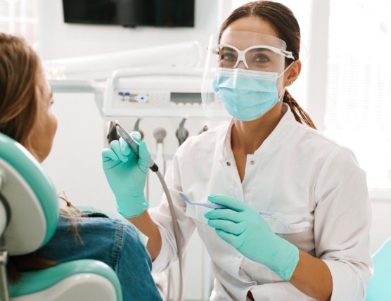 Dental hygienist treating dentistry patient