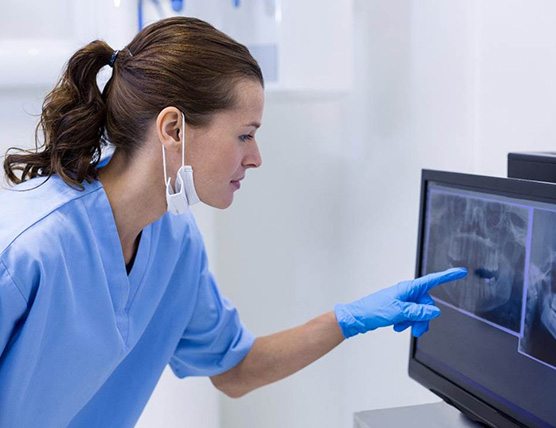 dental assistant looking at x-ray