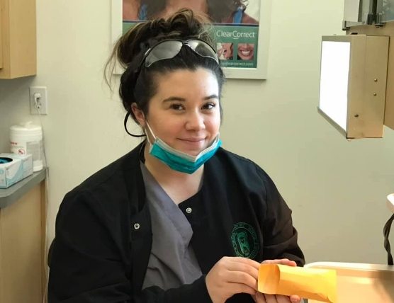 Dental assisting student smiling during training