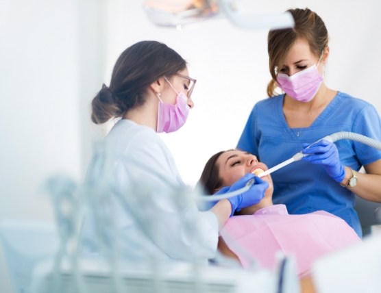 Dental assistant treating dental patient