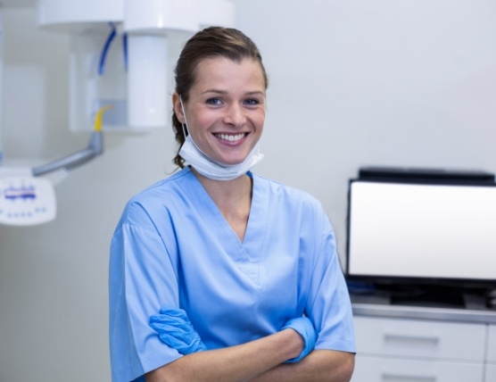 Smiling dental assistant next to chairside computer monitor