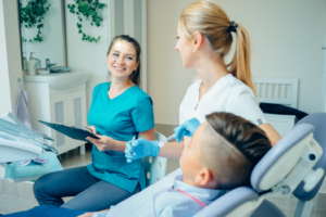 a dental assistant talking with a dentist and patient